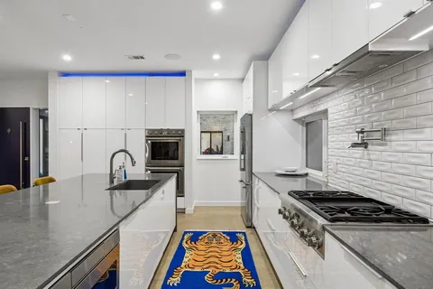 a kitchen with stainless steel appliances granite countertop a sink stove and refrigerator