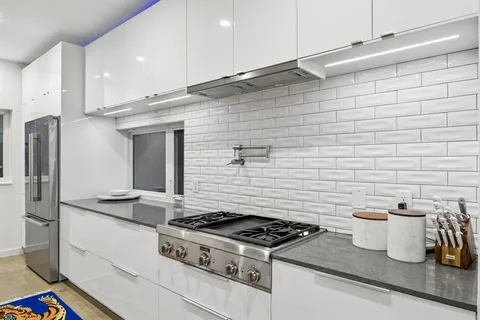a kitchen with granite countertop a stove and a refrigerator