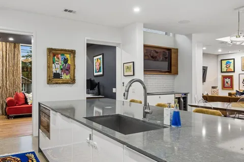 a kitchen with stainless steel appliances granite countertop a sink and a stove top oven with wooden floor