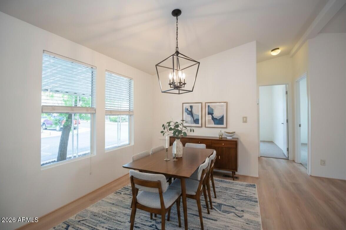 11250 East State Rte 69, Unit 1125 Dewey, AZ 86327 - Photo 10 of 45 a dining room with wooden floor a chandelier a wooden table and chairs