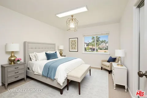 a bedroom with a bed a couch and a window