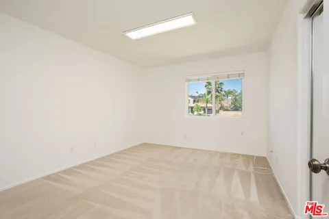 a view of empty room with window and ceiling fan