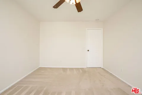 a view of kitchen with refrigerator sink and white cabinet