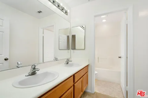 a view of a yard in front of a house with a large tree