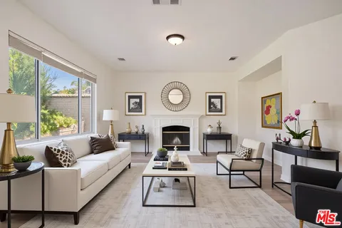 a bedroom with a large bed and a chandelier fan
