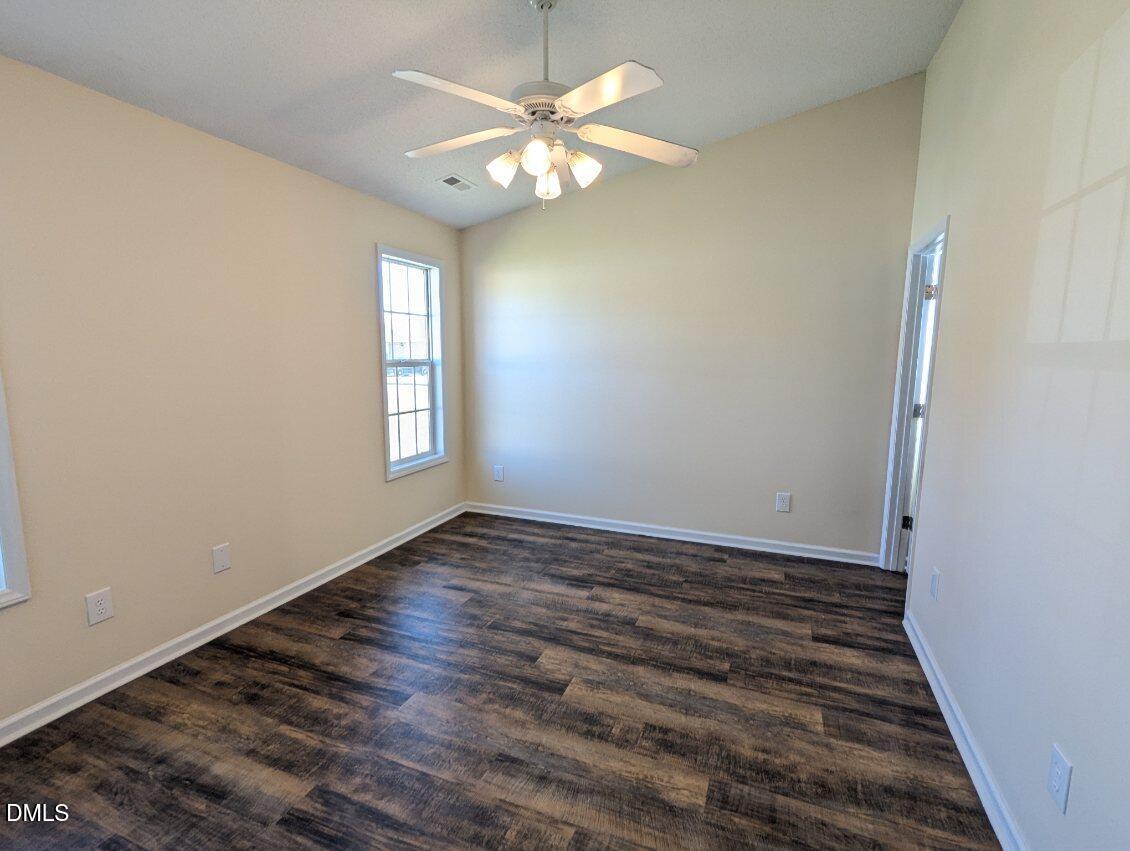 100 Reebe Circle Selma, NC 27576 - Photo 11 of 19 a view of an empty room with window and wooden floor