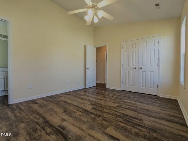 a view of an empty room with wooden floor