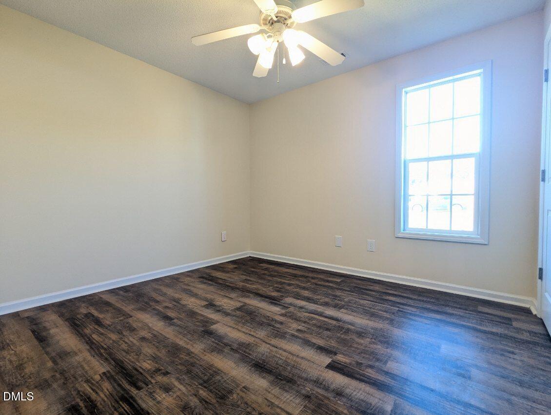 100 Reebe Circle Selma, NC 27576 - Photo 14 of 19 an empty room with wooden floor fan and windows