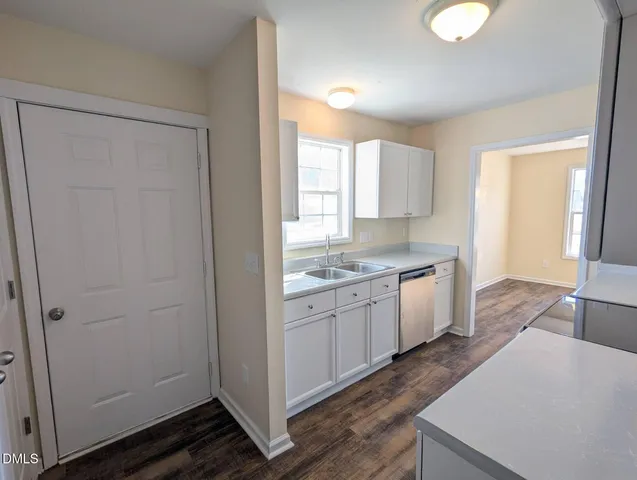 a large kitchen with a sink dishwasher stove and wooden cabinets