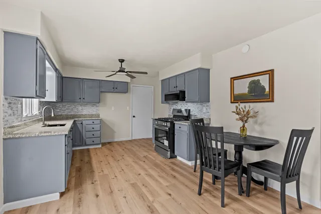 a kitchen with a table chairs refrigerator and microwave