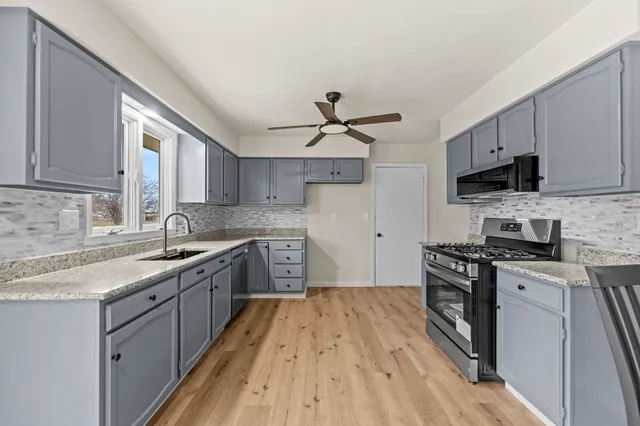 a kitchen with stainless steel appliances granite countertop a sink stove and refrigerator