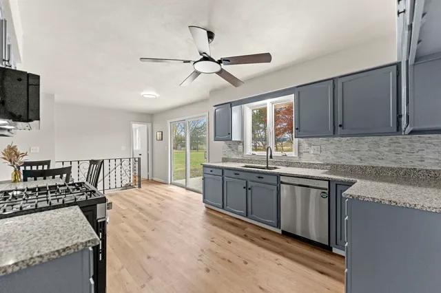 a kitchen with stainless steel appliances granite countertop a sink stove and refrigerator