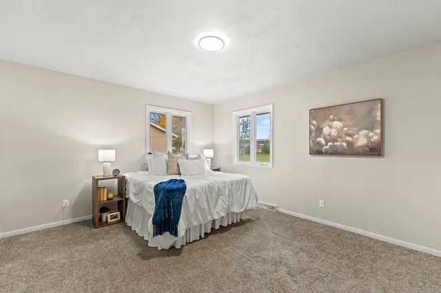 a spacious bedroom with a bed and a window