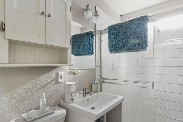 a bathroom with a sink a toilet and mirror