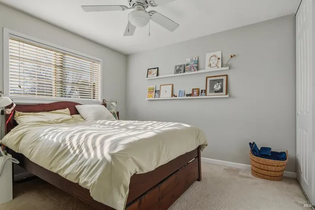 a bedroom with a bed and painting on the wall