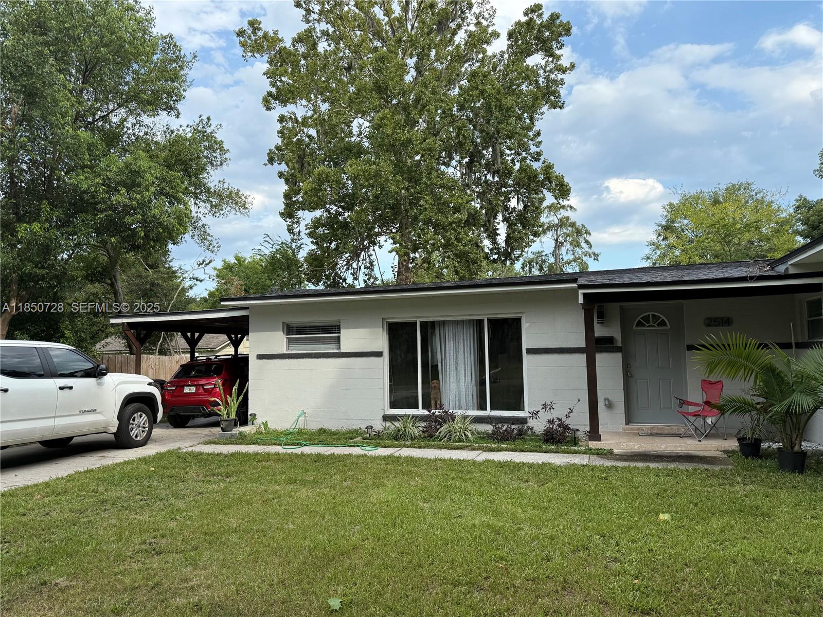 a front view of house with yard and car parked
