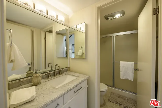 a bathroom with a granite countertop sink toilet and shower