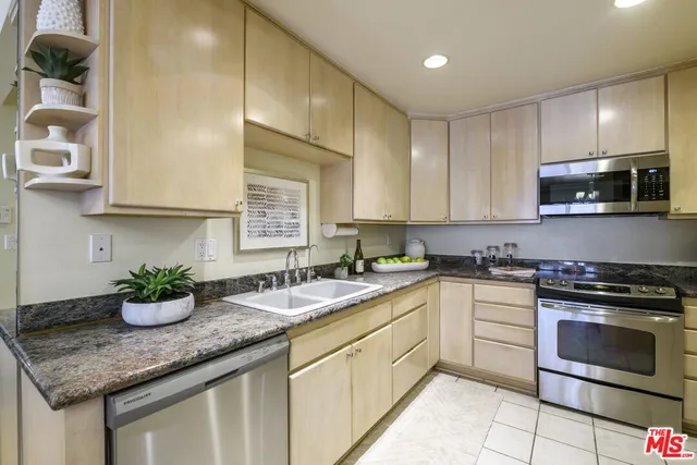 a kitchen with stainless steel appliances granite countertop a sink stove and cabinets