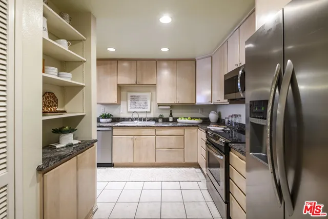a kitchen with a sink a refrigerator and cabinets