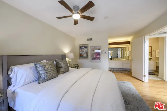 a bedroom with a large bed and a chandelier
