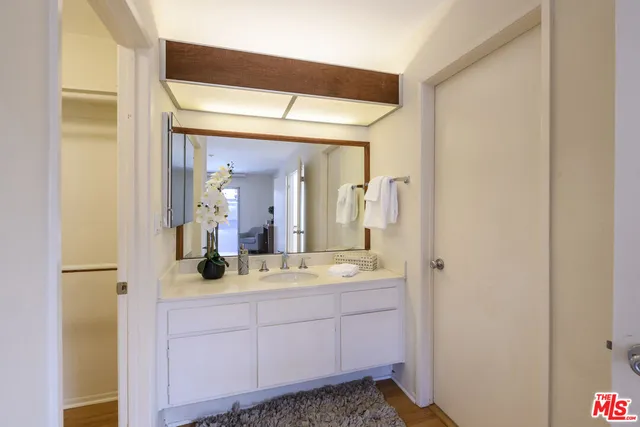 a bathroom with a granite countertop sink and a mirror