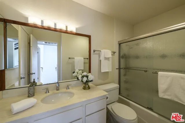 a bathroom with a sink toilet double vanity and shower