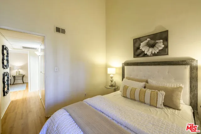 a bedroom with a bed and a painting on the wall