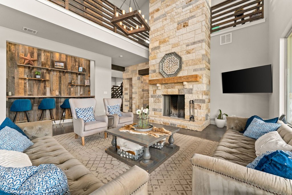 3830 Outback Trail Spicewood, TX 78669 - Photo 18 of 40 a living room with furniture a clock and a flat screen tv