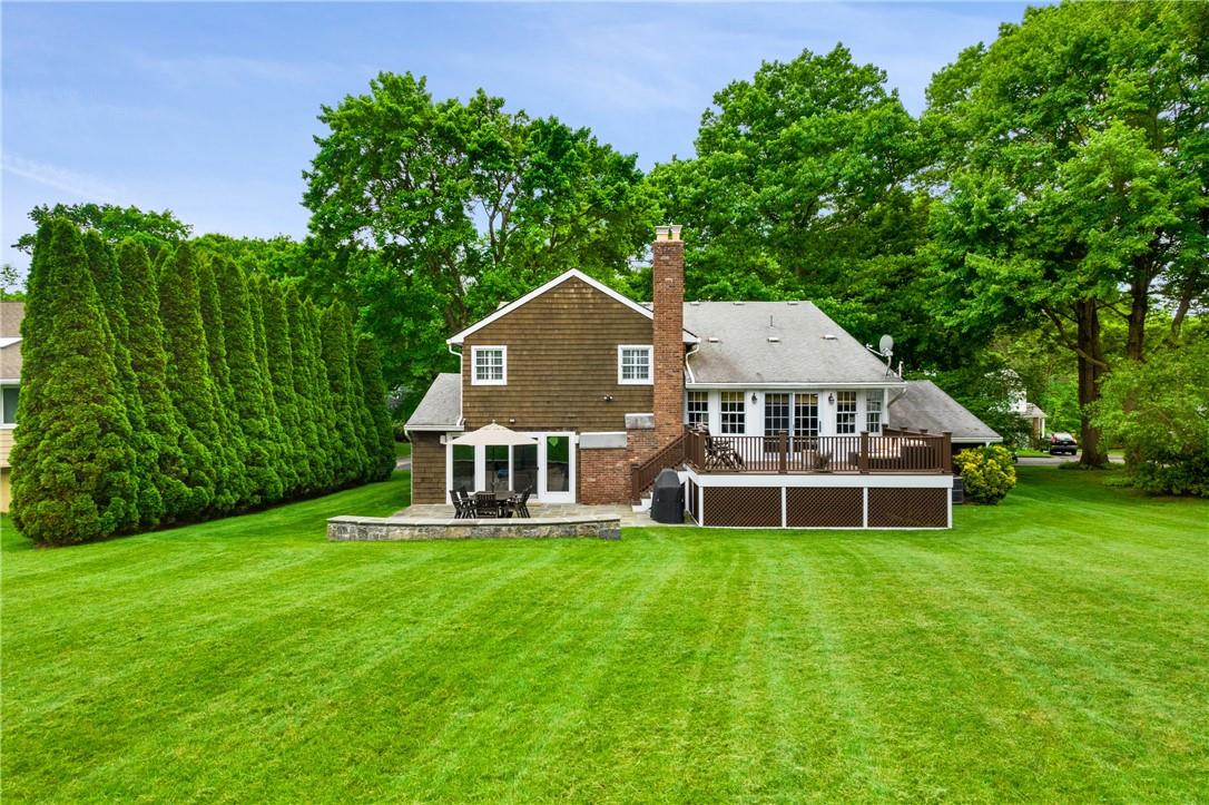 a view of a house with a big yard and large trees