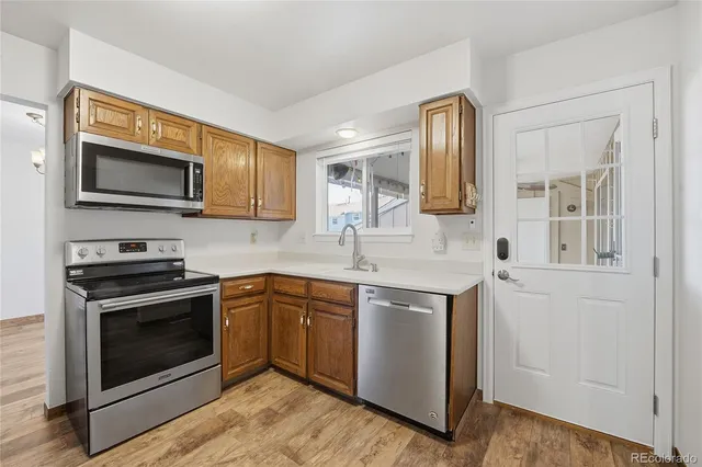 a kitchen with stainless steel appliances granite countertop a stove microwave and sink