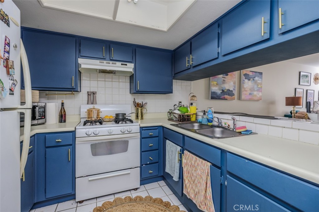 1237 East 6th Street, Unit 110 Long Beach, CA 90802 - Photo 7 of 22 a kitchen with a sink cabinets and stainless steel appliances