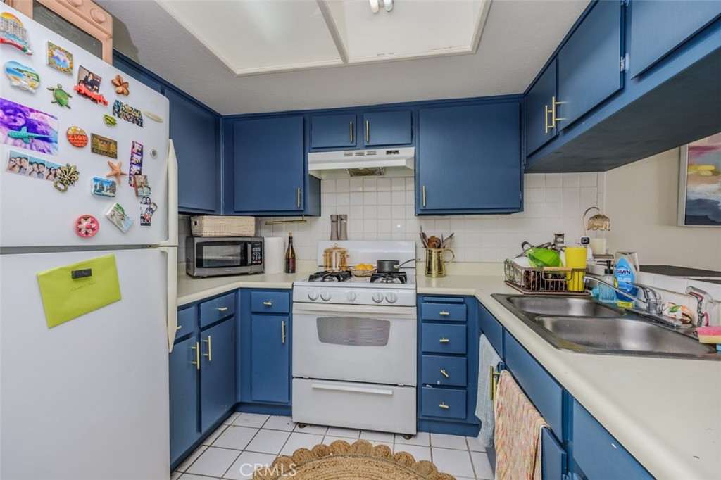 1237 East 6th Street, Unit 110 Long Beach, CA 90802 - Photo 8 of 22 a kitchen with a sink a stove top oven and refrigerator
