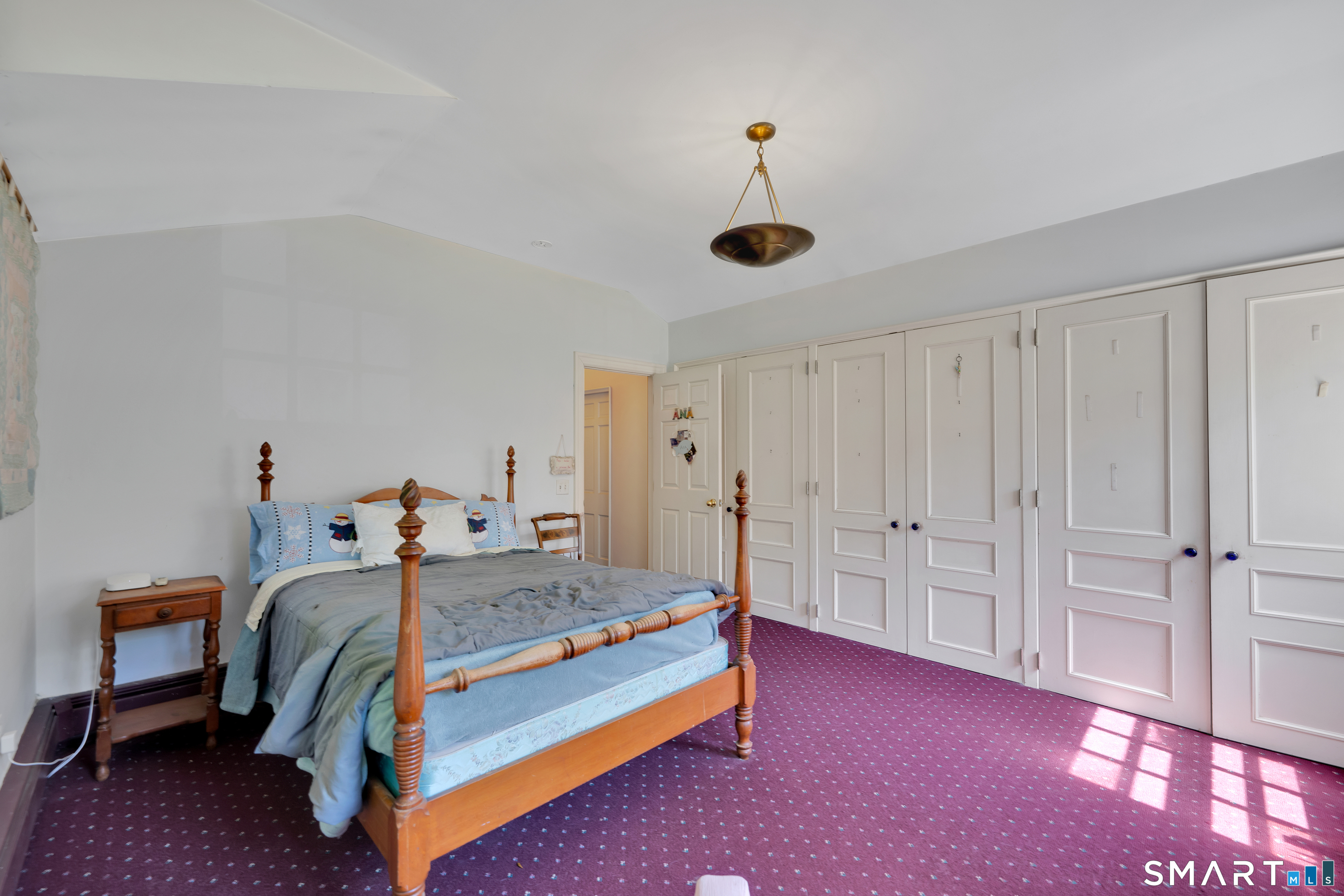 231 B Kent Road Kent, CT 06757 - Photo 18 of 35 a bedroom with a bed and a chandelier