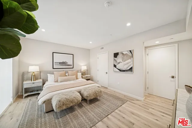 a bedroom with a bed and a painting on the wall