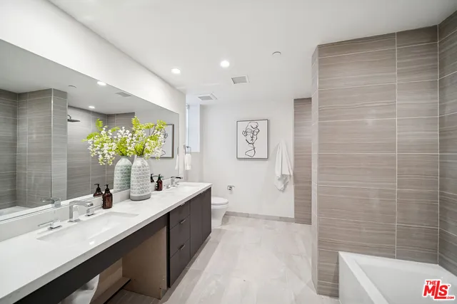 a bathroom with a double vanity sink a toilet and a mirror