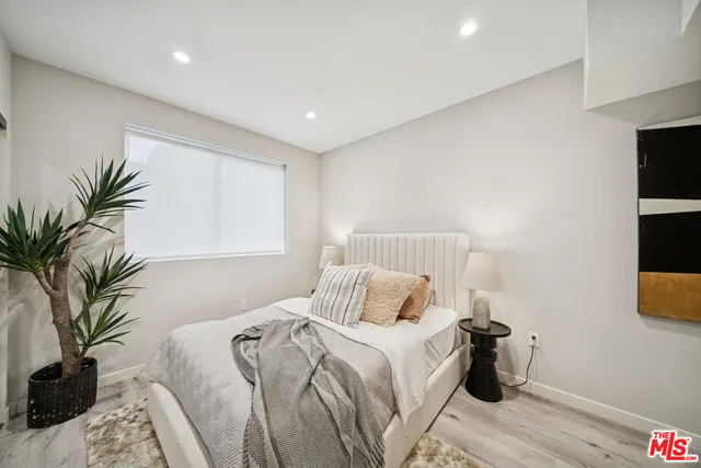 a bedroom with a large bed and a potted plant