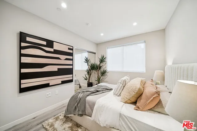 a bedroom with a bed and a painting on the wall