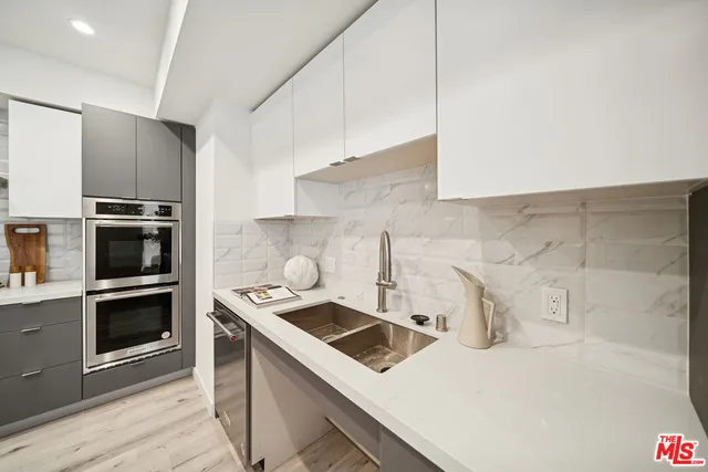 a kitchen with a sink a stove and oven