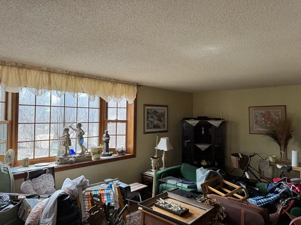 a room with furniture a air conditioner vent and a window