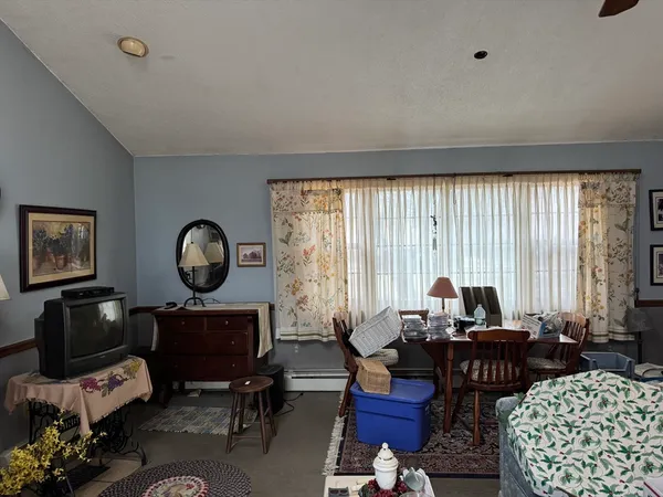 a living room with furniture a fireplace and large windows