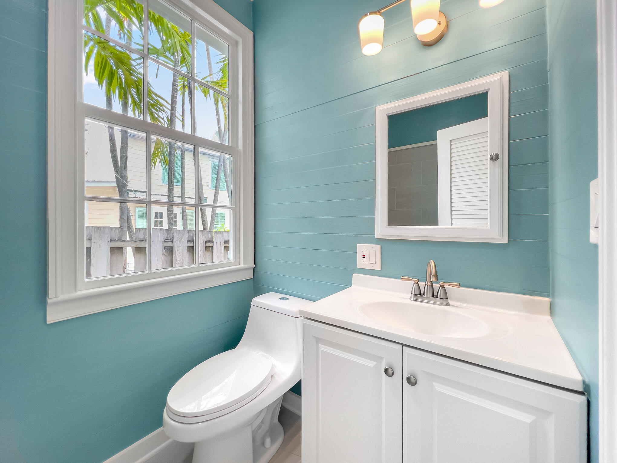 408 William Street Key West, FL 33040 - Photo 29 of 58 a bathroom with a toilet sink and mirror