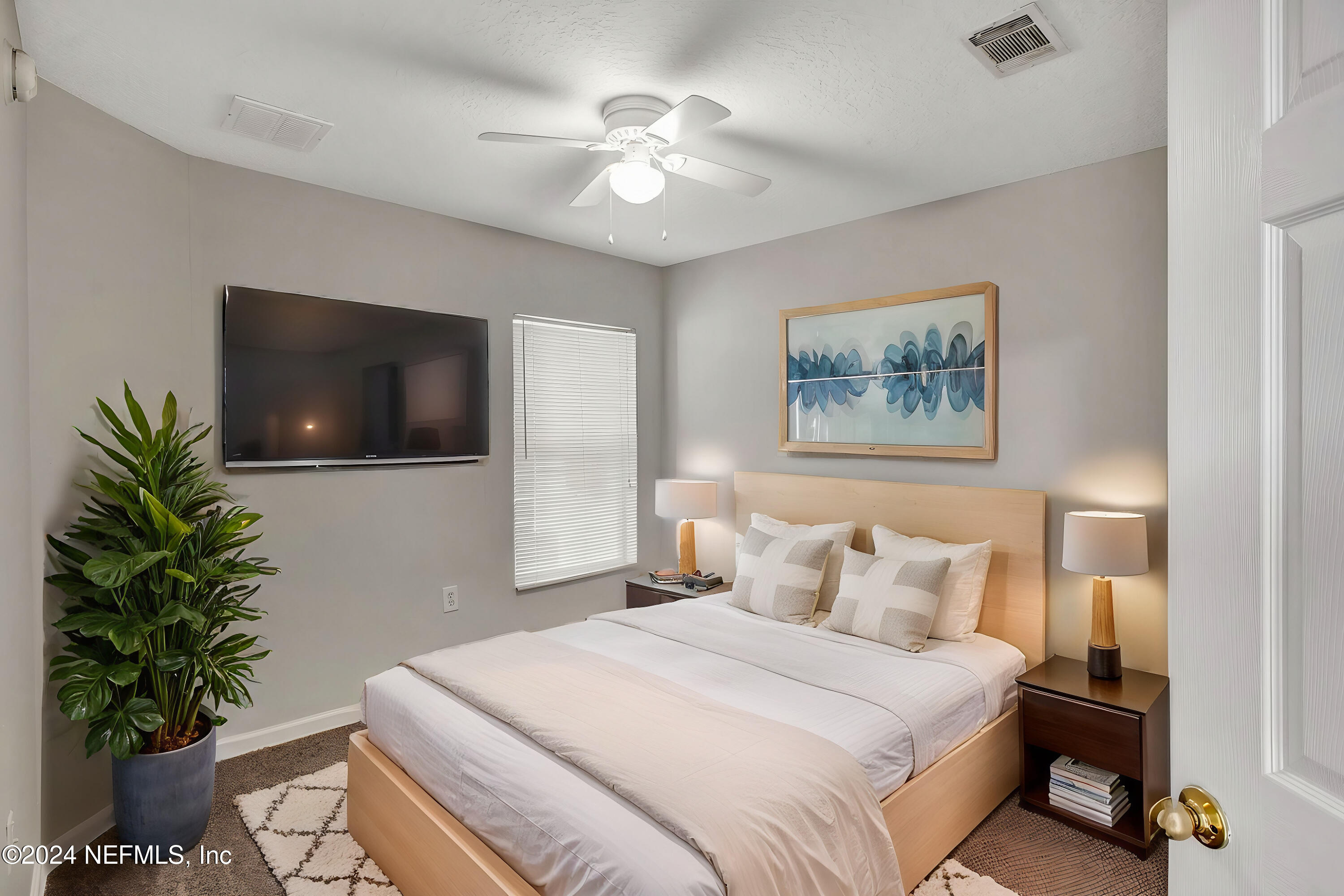 7920 Merrill Road, Unit 1411 Jacksonville, FL 32277 - Photo 10 of 18 a bedroom with a bed and a potted plant
