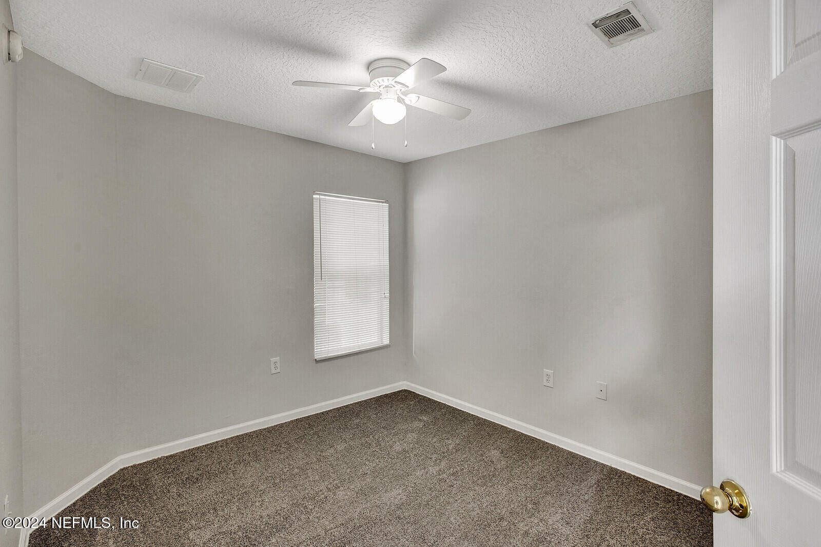7920 Merrill Road, Unit 1411 Jacksonville, FL 32277 - Photo 11 of 18 an empty room with windows and ceiling fan