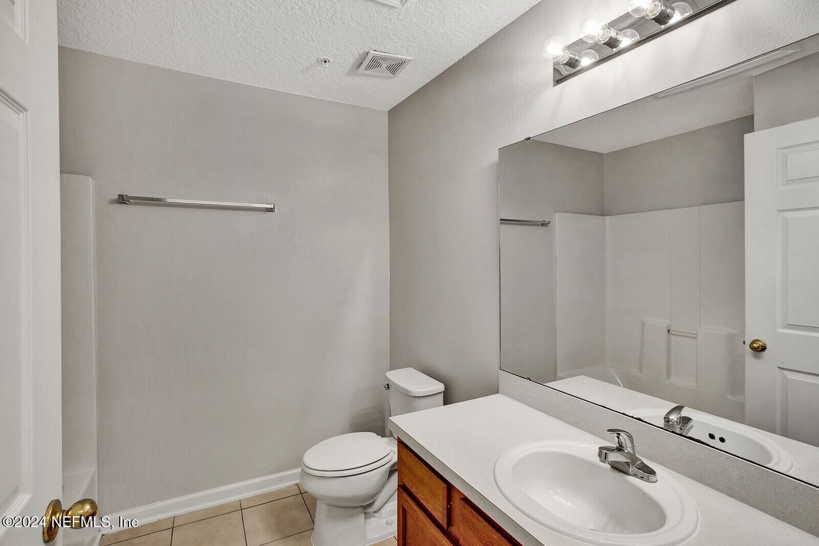 7920 Merrill Road, Unit 1411 Jacksonville, FL 32277 - Photo 13 of 18 a bathroom with a sink toilet and a mirror