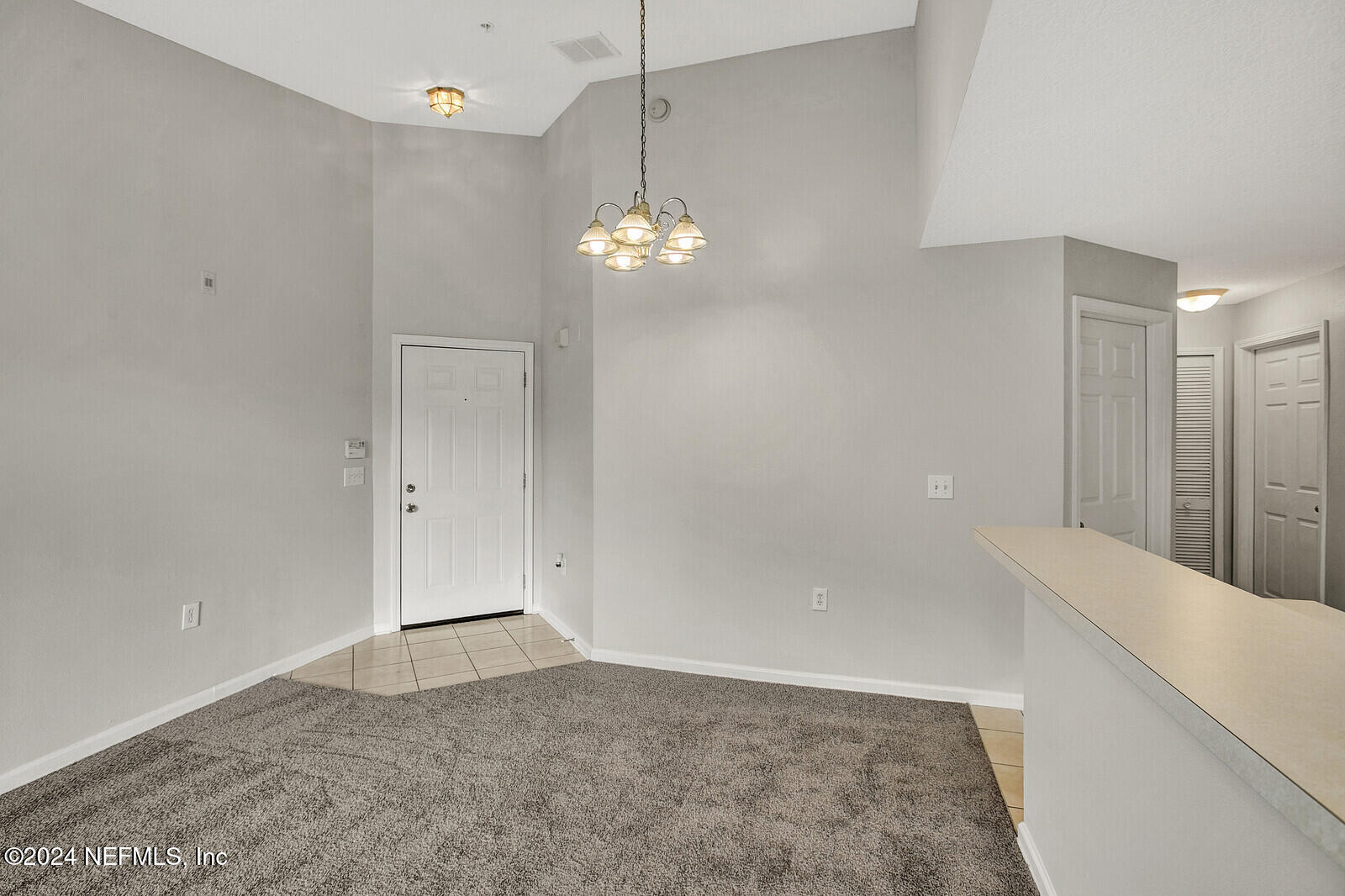 a view of a chandelier in big room and a bathroom