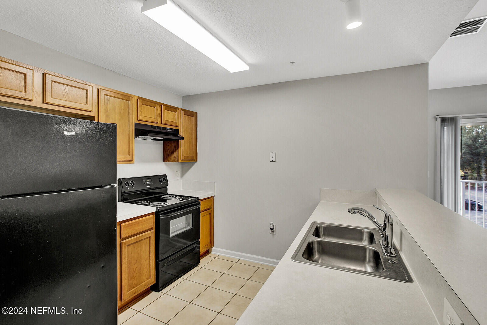 7920 Merrill Road, Unit 1411 Jacksonville, FL 32277 - Photo 4 of 18 a kitchen with a refrigerator and a stove