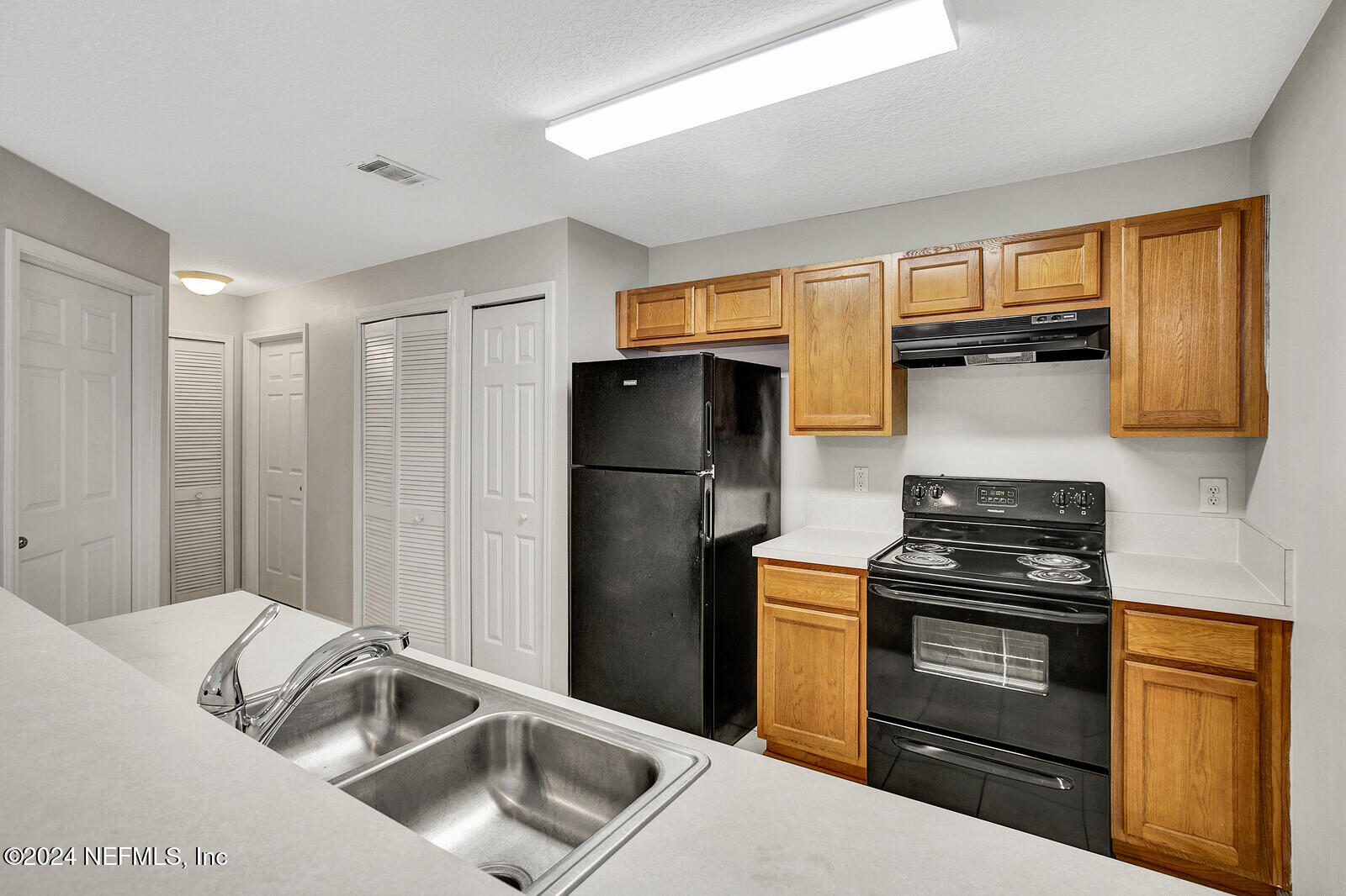 7920 Merrill Road, Unit 1411 Jacksonville, FL 32277 - Photo 5 of 18 a kitchen with a refrigerator and a sink