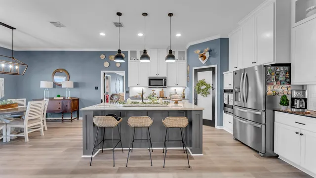 a kitchen with stainless steel appliances kitchen island granite countertop a dining table and chairs