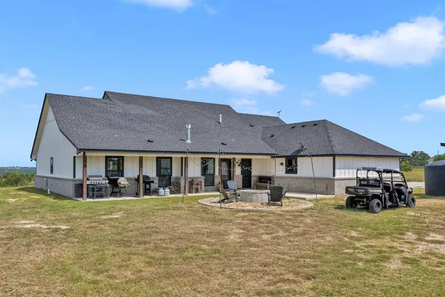 a view of a house with a big yard and large trees