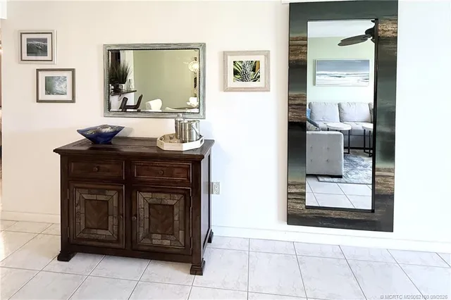 a hallway with a sink a mirror and cabinets